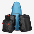 The Cancha Tennis Travel Bundle is displayed against a plain background, featuring a blue Racquet Bag Voyager along with three black bags. These black bags come with convenient wet-dry bag features and vibrant orange zipper pulls.