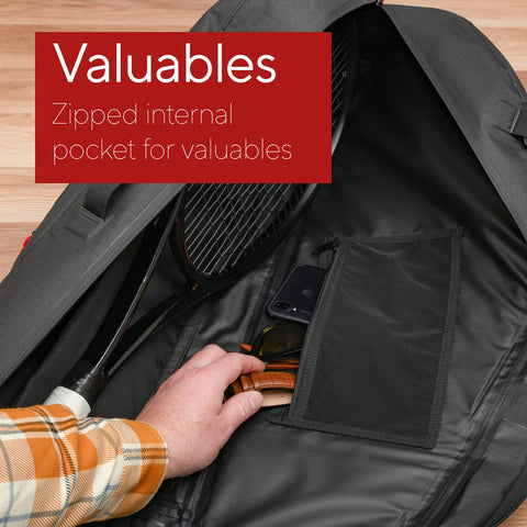 Person placing items into a zippered internal pocket of a black bag. Text overlay reads "Valuables" - "Zipped internal pocket for valuables, perfect for your Cancha Tennis Travel Bundle or other travel accessories.